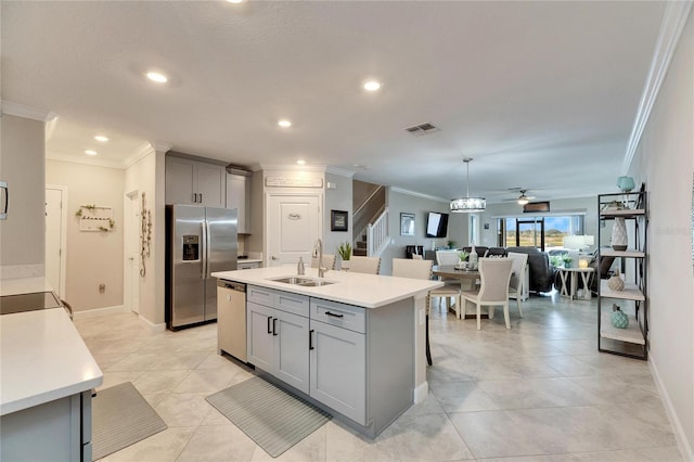 kitchen with a center island with sink, ceiling fan, appliances with stainless steel finishes, gray cabinetry, and sink