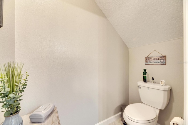 bathroom with toilet, baseboard heating, and lofted ceiling