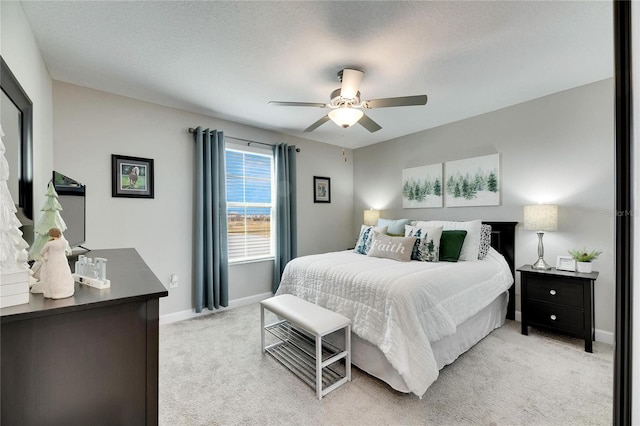 carpeted bedroom with ceiling fan and a textured ceiling