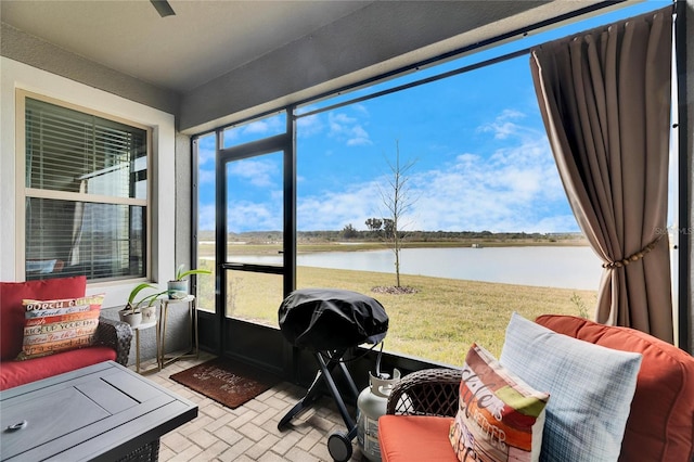 sunroom featuring a water view