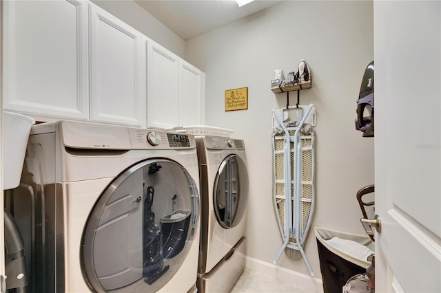 washroom featuring cabinets, light tile patterned floors, and washing machine and dryer