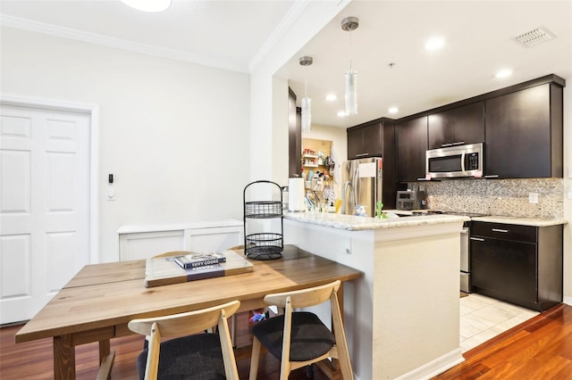 kitchen featuring kitchen peninsula, crown molding, appliances with stainless steel finishes, light hardwood / wood-style floors, and dark brown cabinetry