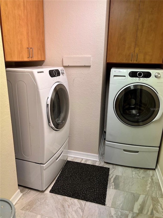 washroom featuring cabinets and washer and dryer