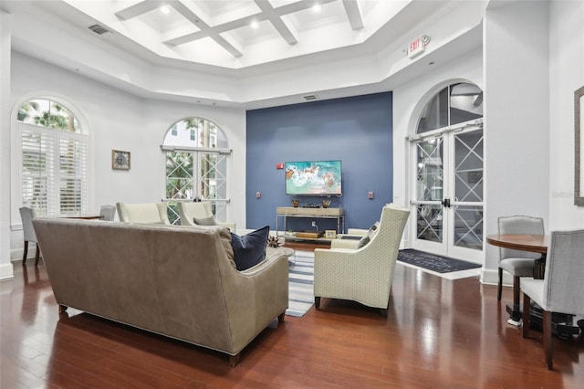 living room with a towering ceiling, coffered ceiling, ornamental molding, beam ceiling, and dark wood-type flooring