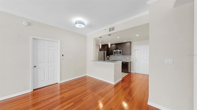 700 S Harbour Island Blvd Unit 226, Tampa, FL 33602 - kitchen featuring stainless steel appliances, light countertops, a peninsula, decorative backsplash, and light wood-type flooring