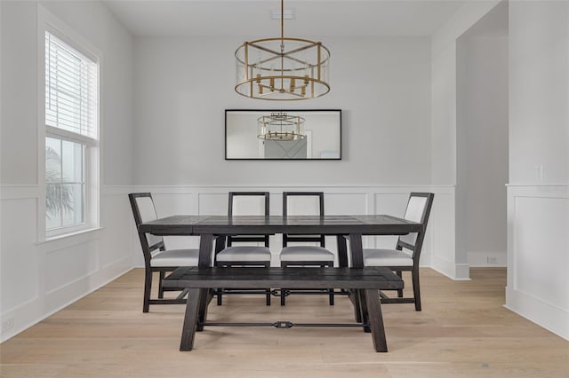 dining space featuring a notable chandelier and light hardwood / wood-style floors