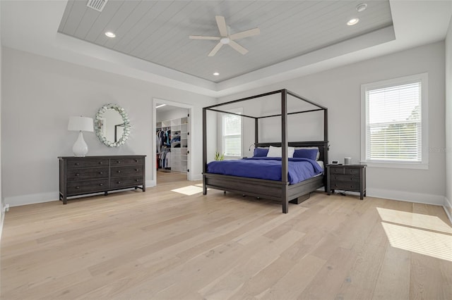 bedroom featuring a spacious closet, ceiling fan, a raised ceiling, and wooden ceiling