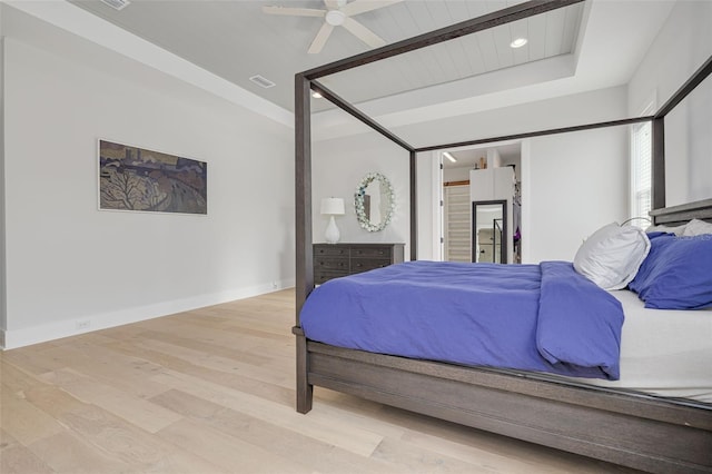 bedroom featuring a spacious closet, ceiling fan, and light hardwood / wood-style flooring