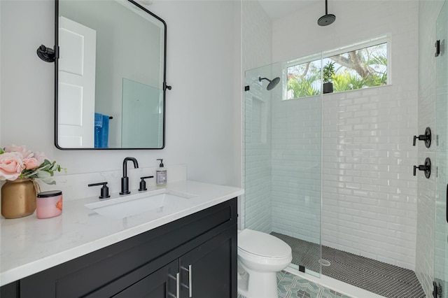 bathroom featuring toilet, a shower with shower door, and vanity