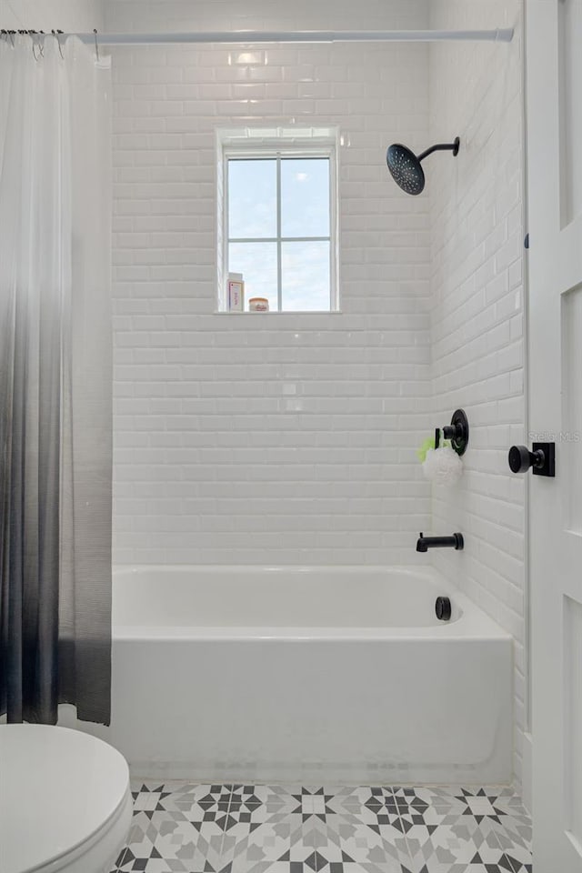 bathroom featuring shower / bath combo with shower curtain, tile patterned floors, and toilet