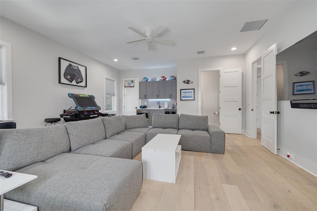 living room featuring ceiling fan and light hardwood / wood-style floors