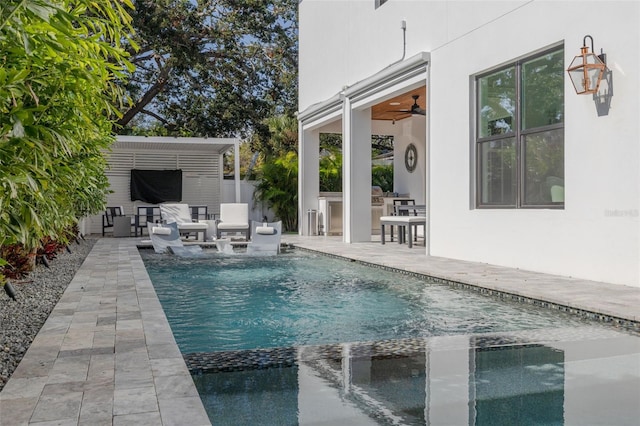 view of swimming pool featuring ceiling fan, a patio, exterior kitchen, and an outdoor bar