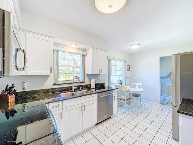 kitchen with white cabinets, dark stone countertops, sink, and stainless steel appliances