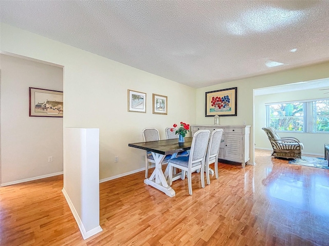 dining area featuring light hardwood / wood-style floors and a textured ceiling