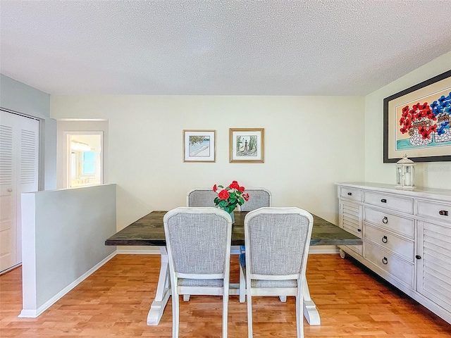 dining area featuring light hardwood / wood-style floors and a textured ceiling