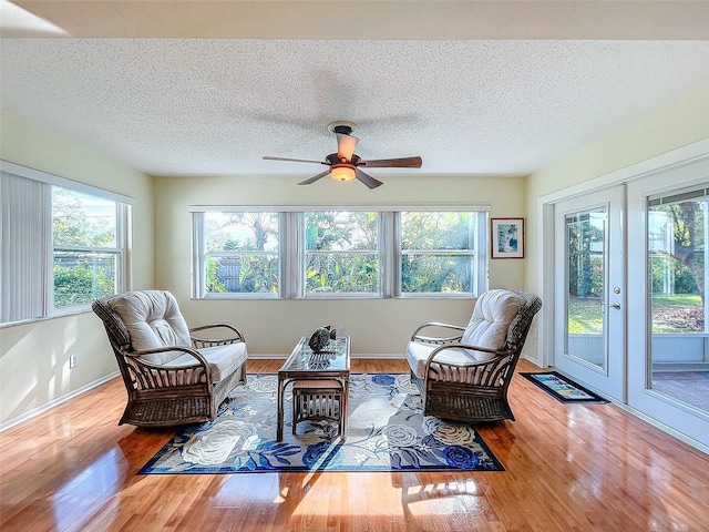 sunroom featuring french doors, ceiling fan, and a healthy amount of sunlight