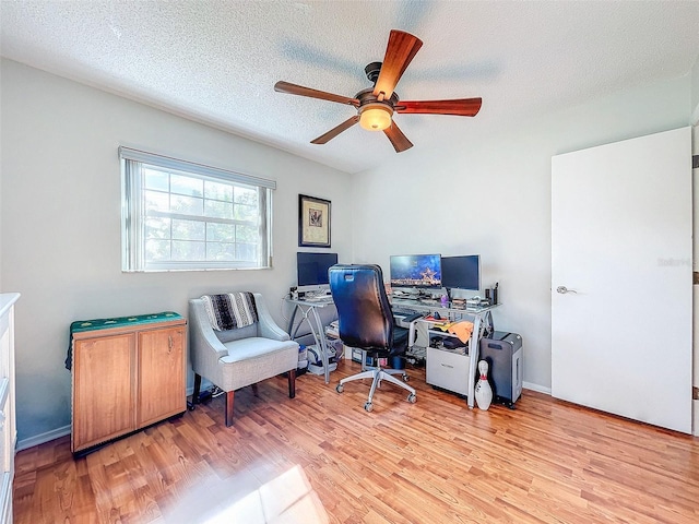 office featuring ceiling fan, light hardwood / wood-style floors, and a textured ceiling