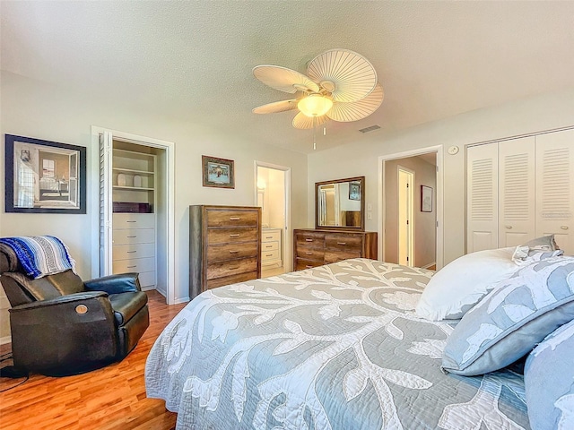 bedroom featuring hardwood / wood-style flooring, ceiling fan, and a textured ceiling