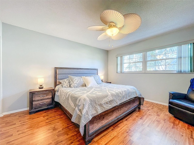 bedroom featuring a textured ceiling, light wood-type flooring, and ceiling fan