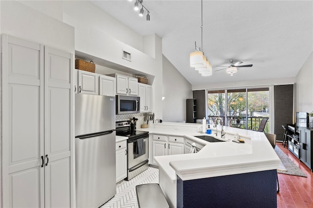 kitchen featuring pendant lighting, sink, ceiling fan, white cabinetry, and stainless steel appliances