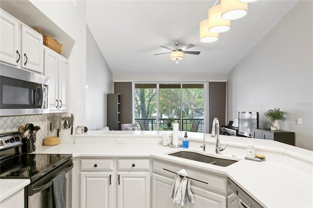 kitchen featuring white cabinetry, sink, ceiling fan, kitchen peninsula, and appliances with stainless steel finishes