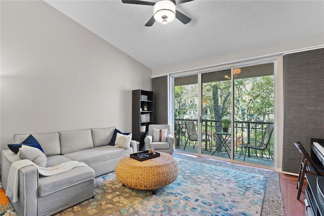 living room with a textured ceiling, ceiling fan, vaulted ceiling, and hardwood / wood-style flooring