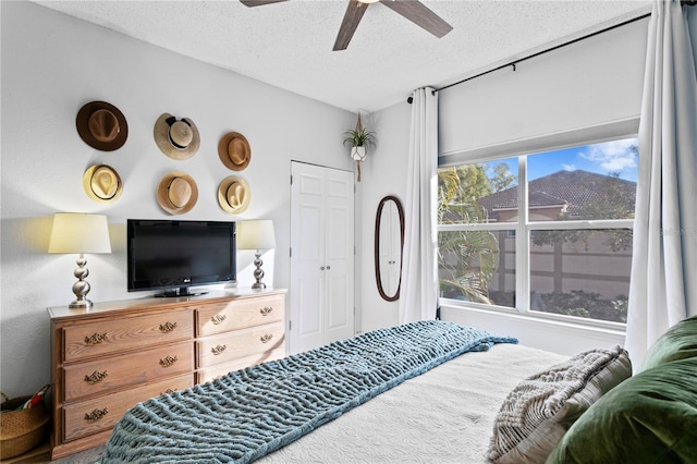 bedroom with ceiling fan and a textured ceiling