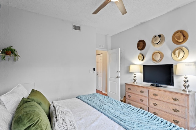 bedroom with ceiling fan and a textured ceiling