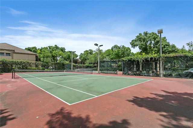 view of tennis court with basketball hoop