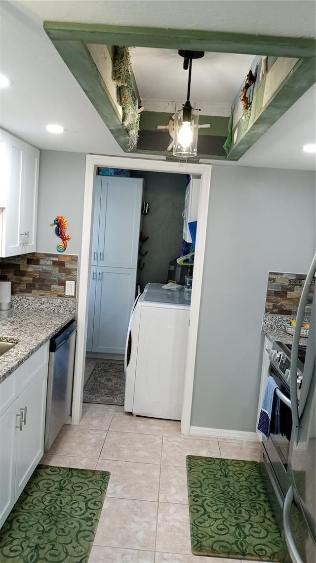 clothes washing area featuring light tile patterned flooring and washer / clothes dryer