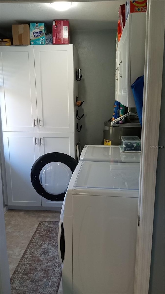 clothes washing area with washing machine and dryer and cabinets