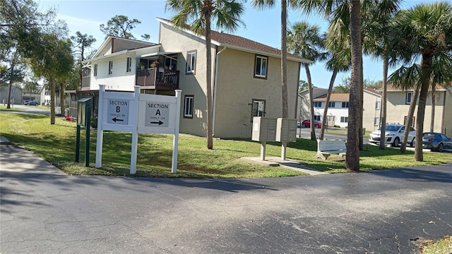 view of side of property with a yard and a mail area