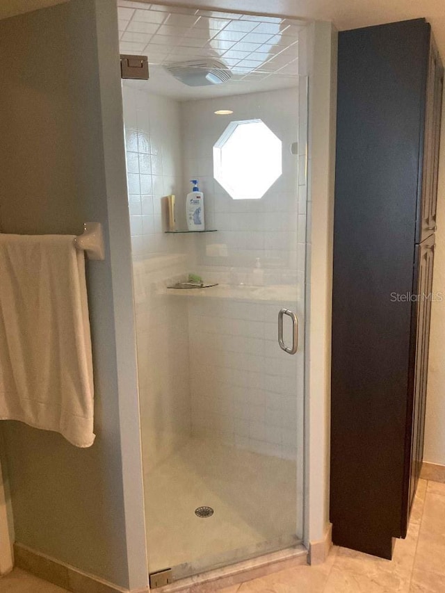 bathroom featuring a shower with door and tile patterned flooring