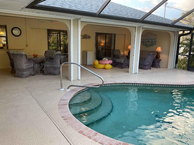 view of pool featuring an outdoor hangout area, glass enclosure, and a patio area