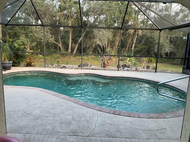 view of pool with a patio and glass enclosure