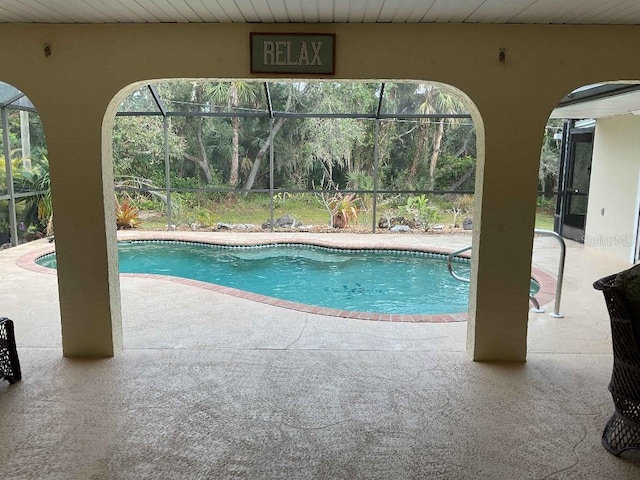 view of swimming pool featuring a patio and glass enclosure