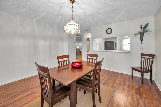 dining space featuring an inviting chandelier, a textured ceiling, and hardwood / wood-style flooring