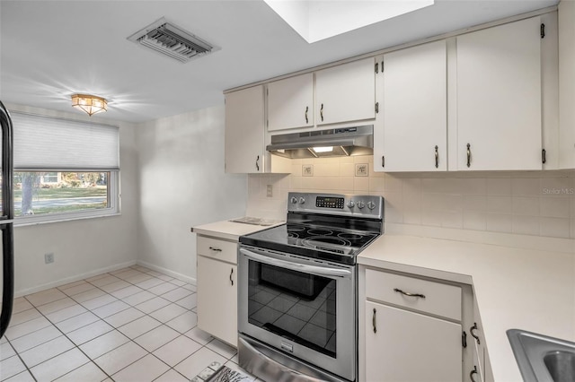 kitchen with electric range, sink, light tile patterned floors, tasteful backsplash, and white cabinets