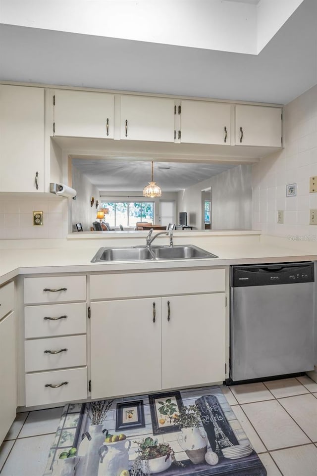 kitchen featuring stainless steel dishwasher, pendant lighting, light tile patterned floors, and sink