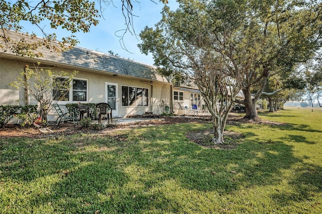 rear view of property with a yard