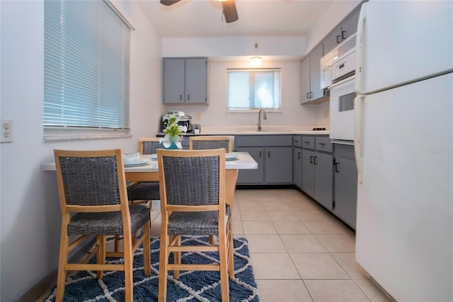 kitchen featuring gray cabinets, white appliances, sink, and light tile patterned floors