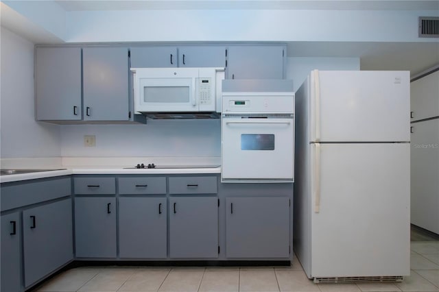 kitchen featuring white appliances, sink, and light tile patterned floors