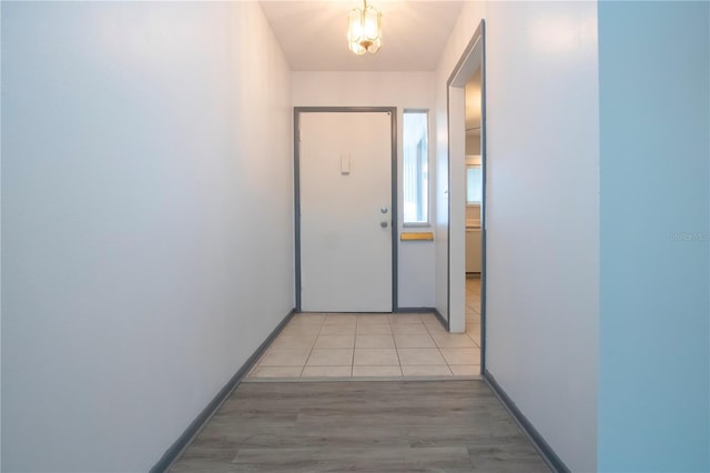 doorway to outside with light tile patterned floors and an inviting chandelier