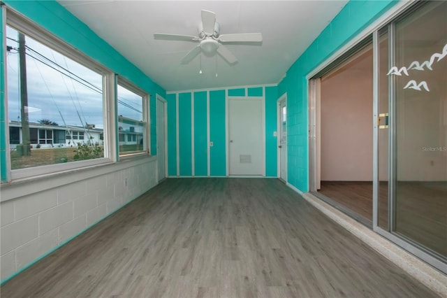 unfurnished sunroom with ceiling fan