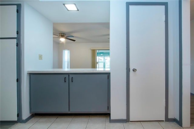 kitchen with light tile patterned floors, gray cabinets, and ceiling fan