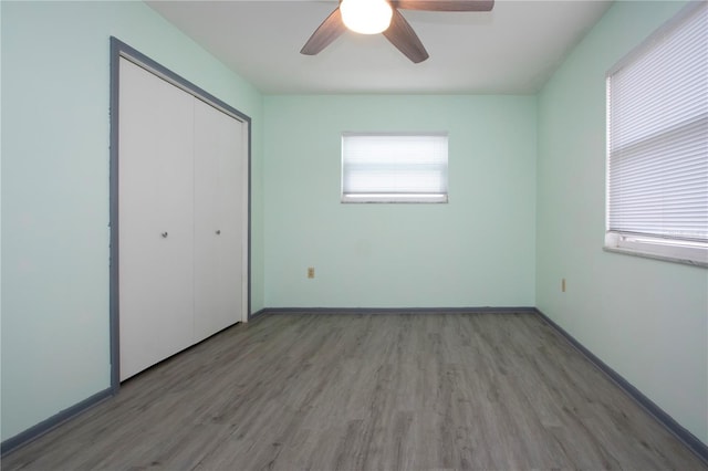 unfurnished bedroom with ceiling fan, light wood-type flooring, and a closet