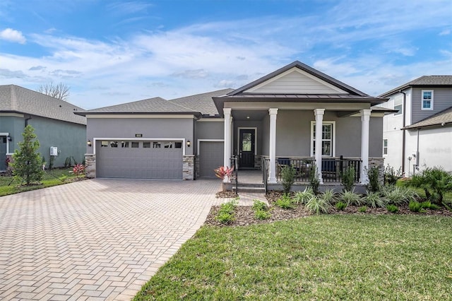 view of front of house with a porch, a garage, and a front yard