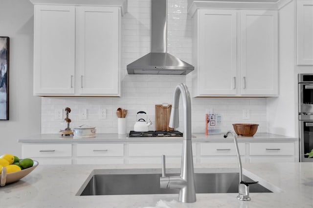 kitchen with white cabinets and wall chimney exhaust hood