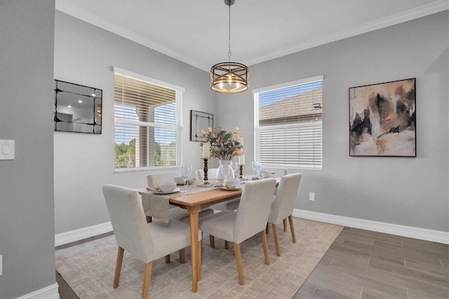 dining space with a wealth of natural light, crown molding, and a notable chandelier