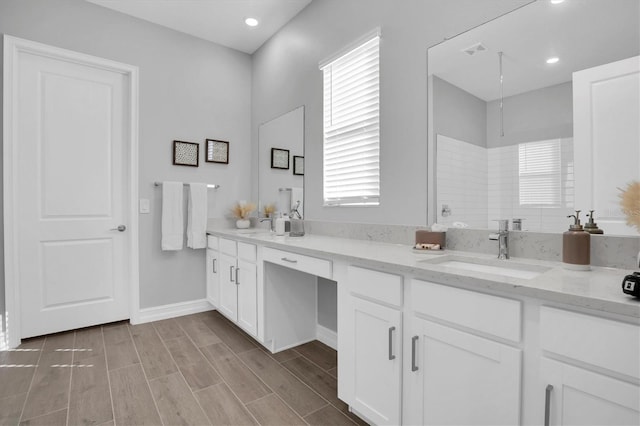 bathroom with plenty of natural light, vanity, and walk in shower